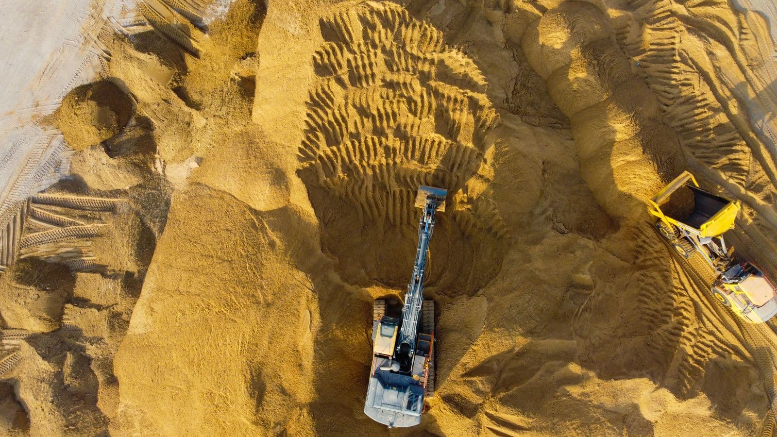 Aerial view of a silica sand quarry with excavation machinery in Gujarat